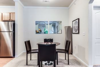 A dining room with a table and chairs.